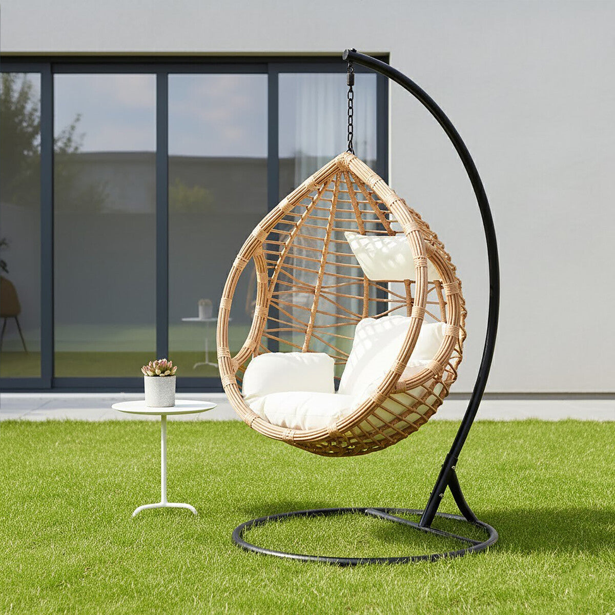 Orsina Goa Natural Rattan Effect Egg Hanging Chair with cream cushions in a bright living room – boho decor reading nook with black metal frame and woven rattan texture