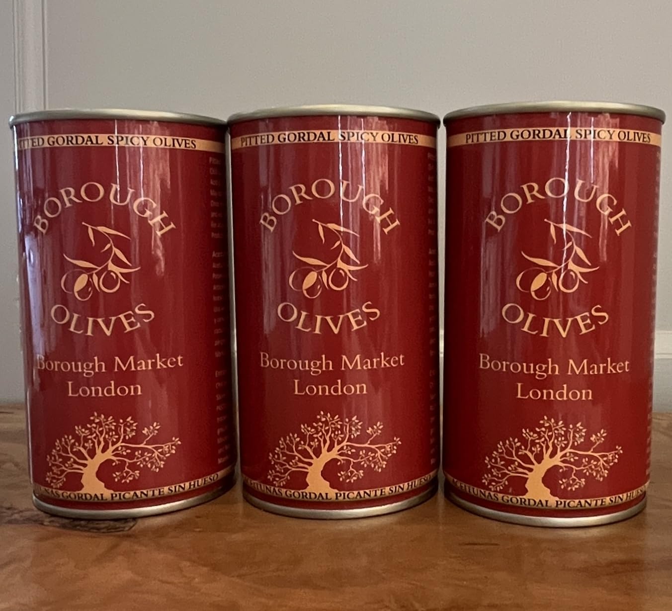 Borough Olives Pitted Green Gordal Spicy Olives 3 x 350g multipack jars on a wooden board with charcuterie and bread