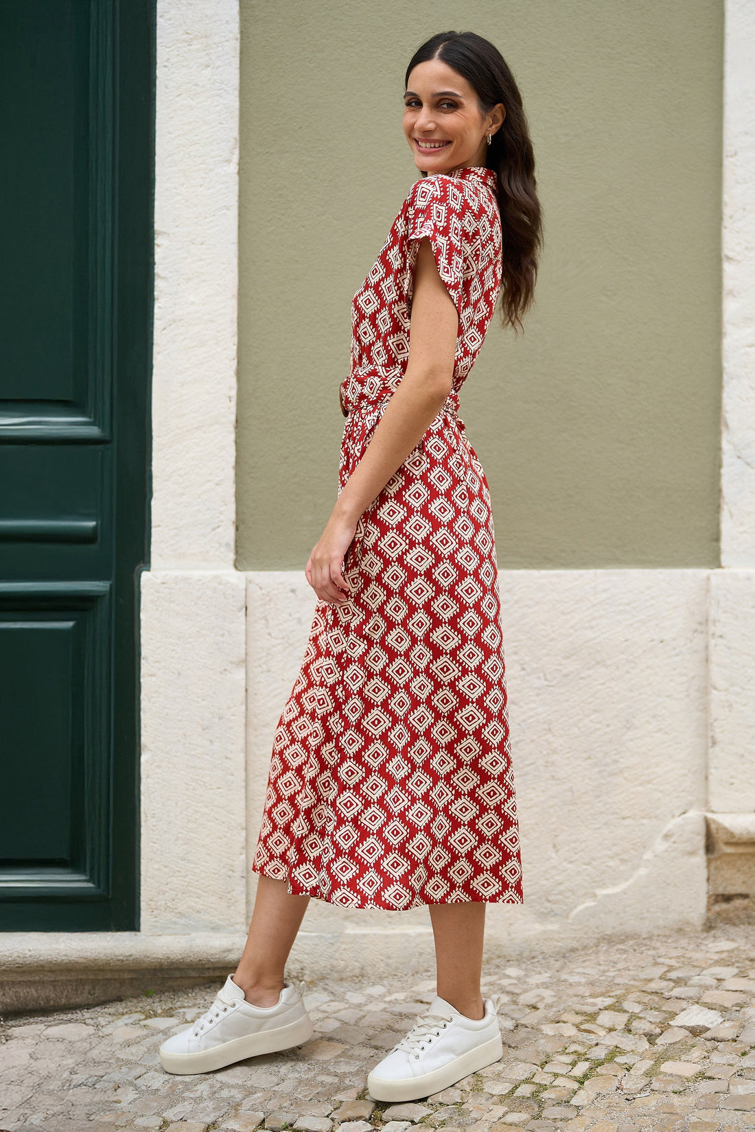 Yumi red viscose midi shirt dress with matching belt shown on a model in a lifestyle setting, featuring a bold red colour and belted waist silhouette