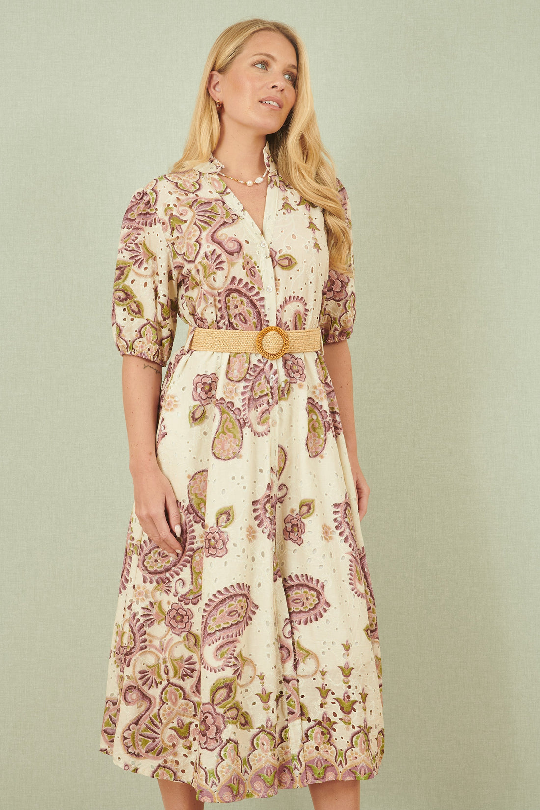 Yumi White Paisley Print Broderie Anglaise Cotton Midi Dress full length front view showing the button up shirt style skater shape puffed three quarter sleeves woven belt and all-over paisley print in 100% cotton broderie anglaise fabric