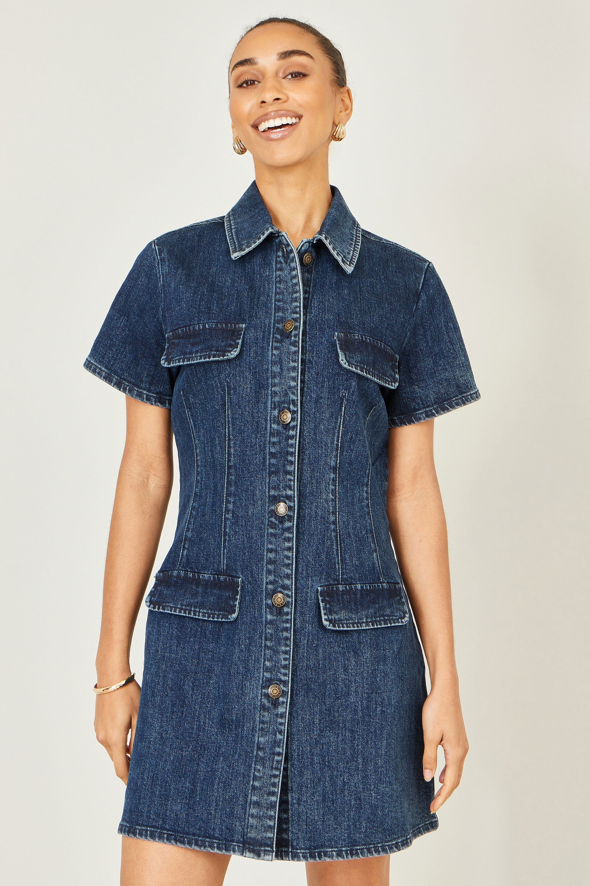 Yumi Blue Denim Stretch Shirt Dress with pocket details, front view on model showing the relaxed fit and button-through design