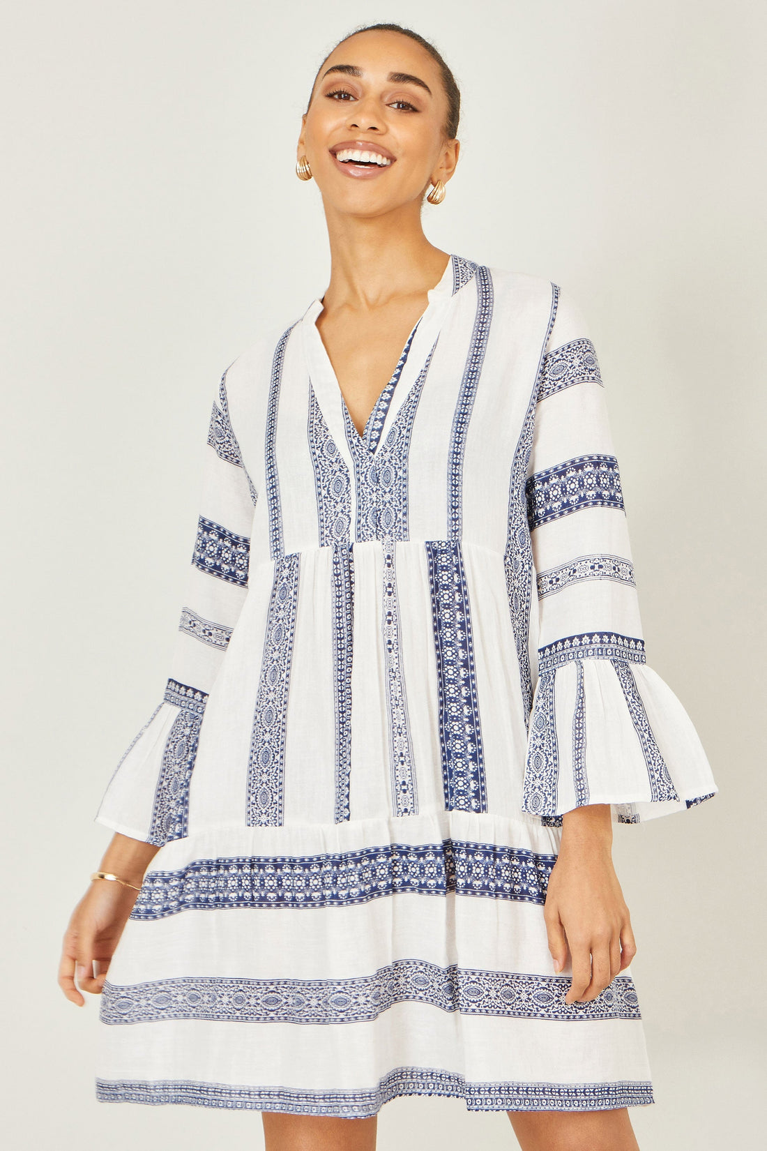 Yumi White Cotton Stripe Tunic – 100% cotton blue-and-white stripe print tunic with V-neckline, gathered silhouette, flared sleeves and tiered hem, relaxed fit 95cm length for warm weather holidays and casual outings