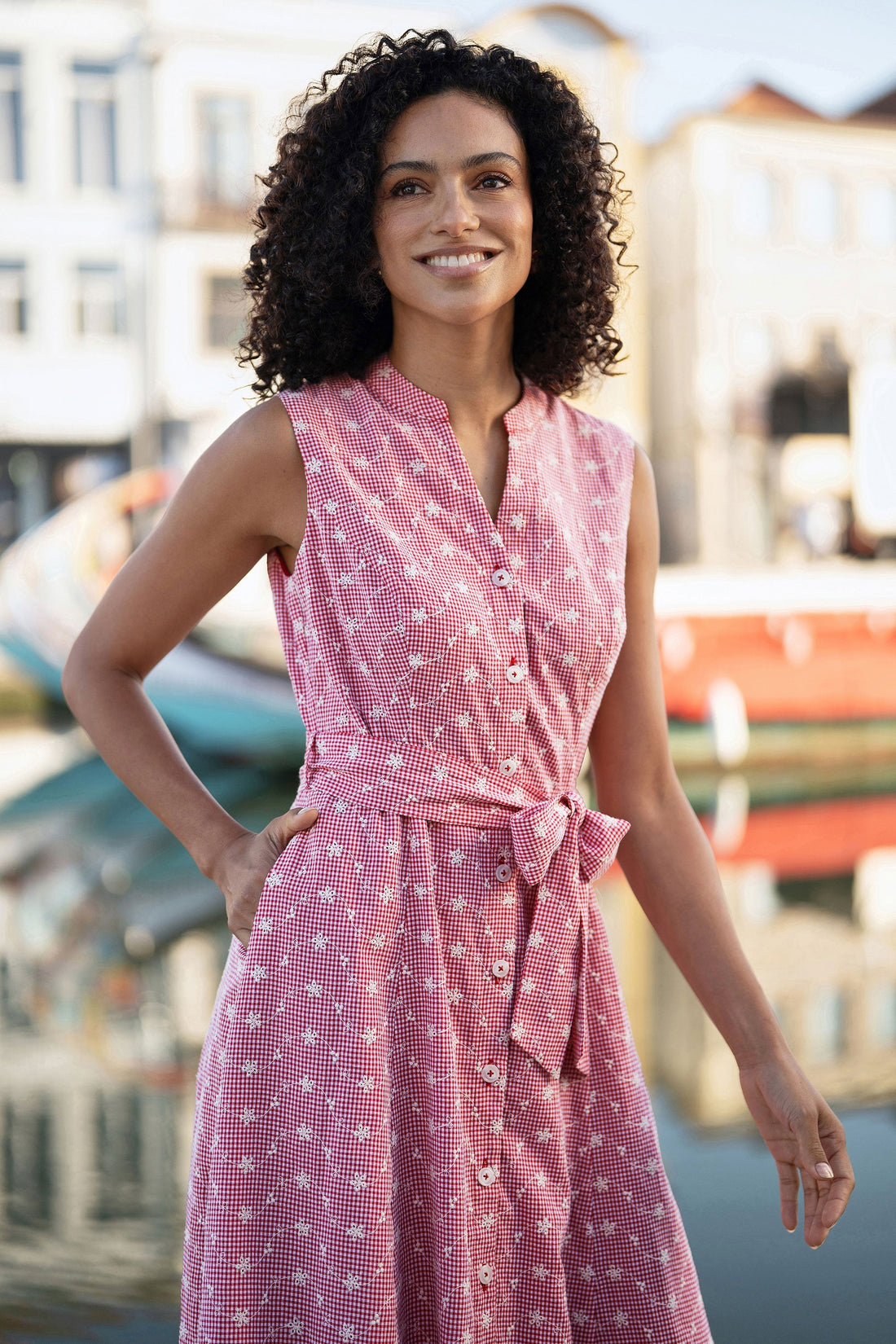 Clara wearing the Yumi Red Broderie Anglaise Embroidered Sleeveless Shirt Dress at a summer garden party