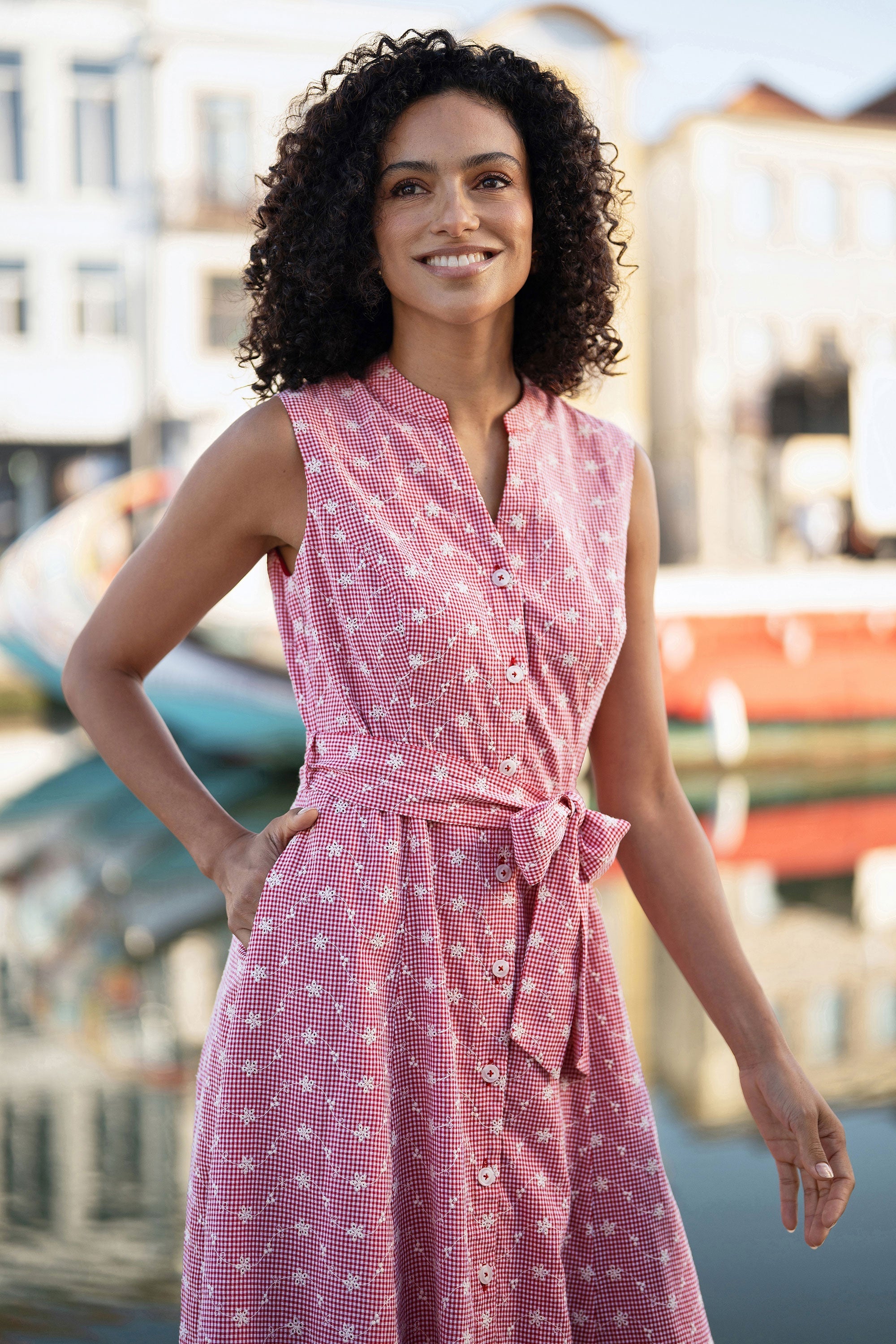 Clara wearing the Yumi Red Broderie Anglaise Embroidered Sleeveless Shirt Dress at a summer garden party