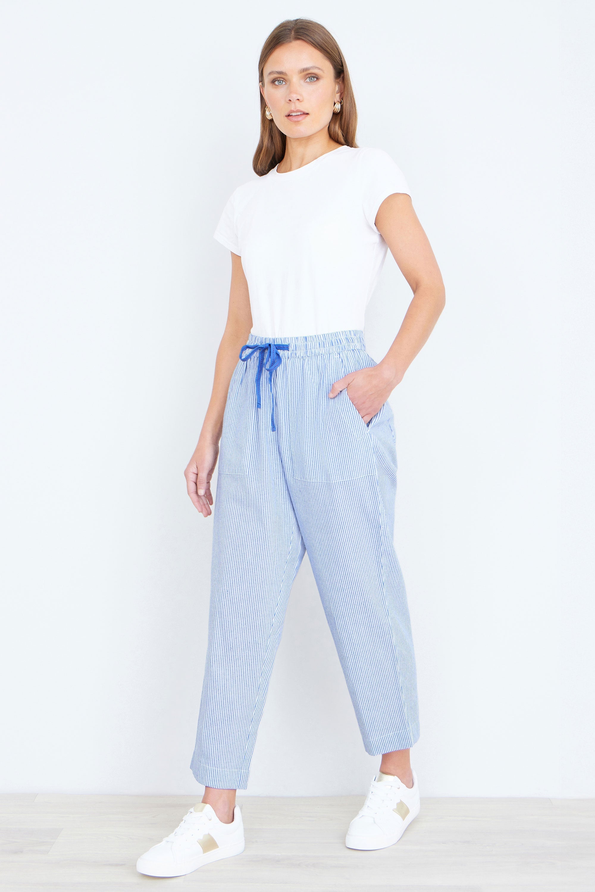 Yumi Blue Cotton Stripe Cropped Trousers shown styled in a casual summer outfit displaying the blue and white stripe pattern, relaxed tapered fit and cropped length