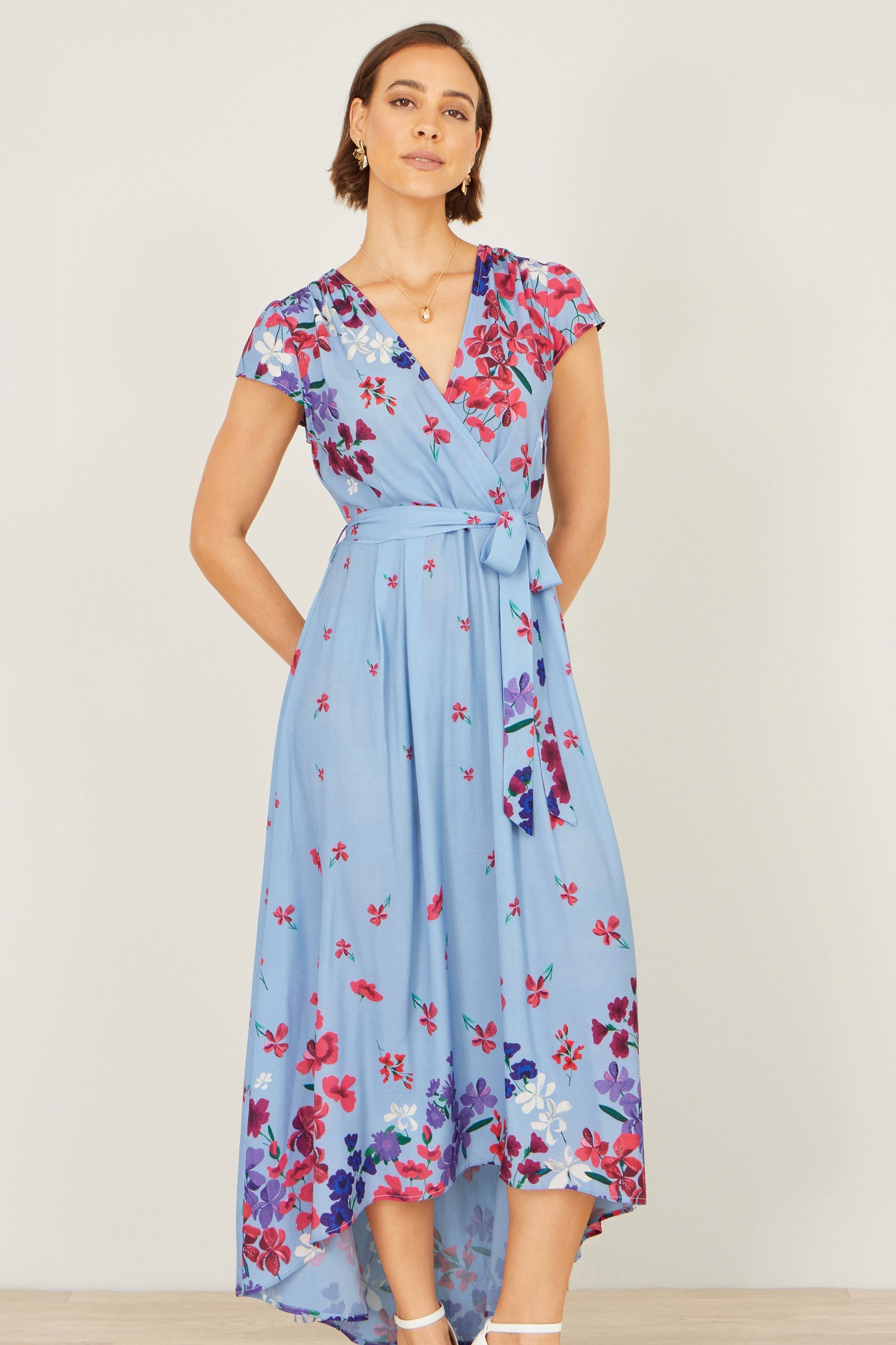 Yumi Blue Floral Mirror Wrap High Low Midi Wrap Dress in blue floral print with V-neckline and flowing high-low hem