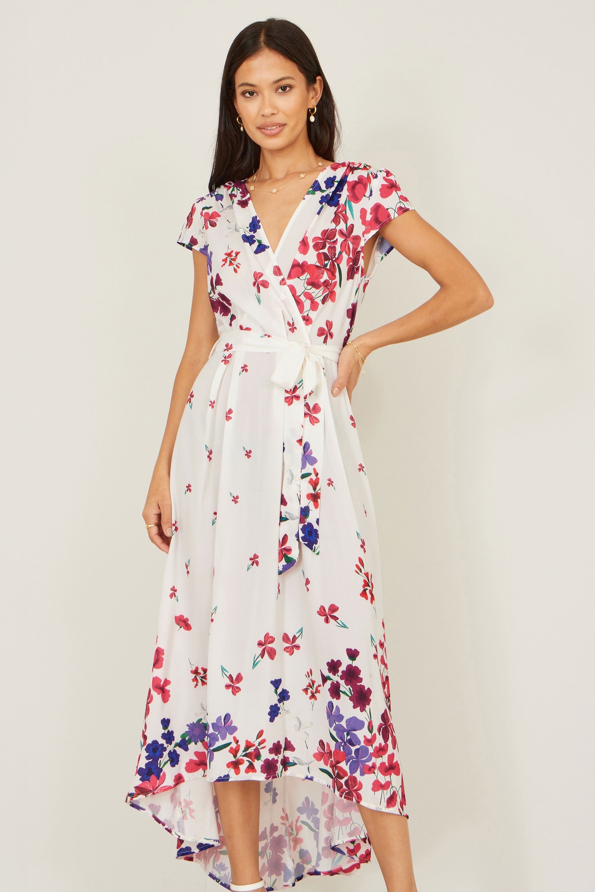 Yumi Ivory Floral Mirror Wrap Dress with dip hem — front view showing the V-neckline, self-tie waist belt and ivory base with red, pink and purple floral print