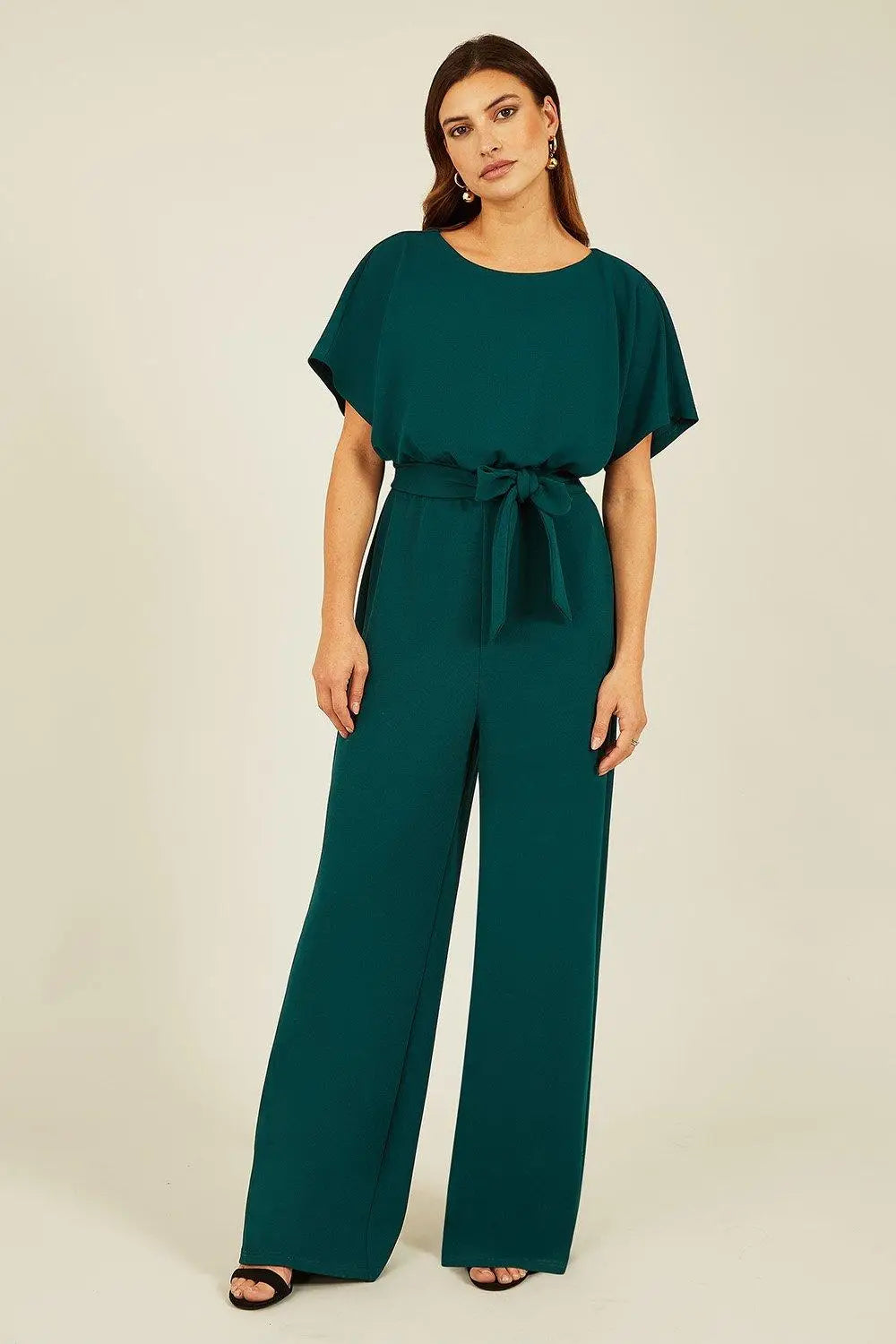 Mela Green Batwing Stretch Jumpsuit — 95% polyester 5% elastane wide leg jumpsuit with batwing sleeves and self-tie waist detail in emerald green, 149cm length