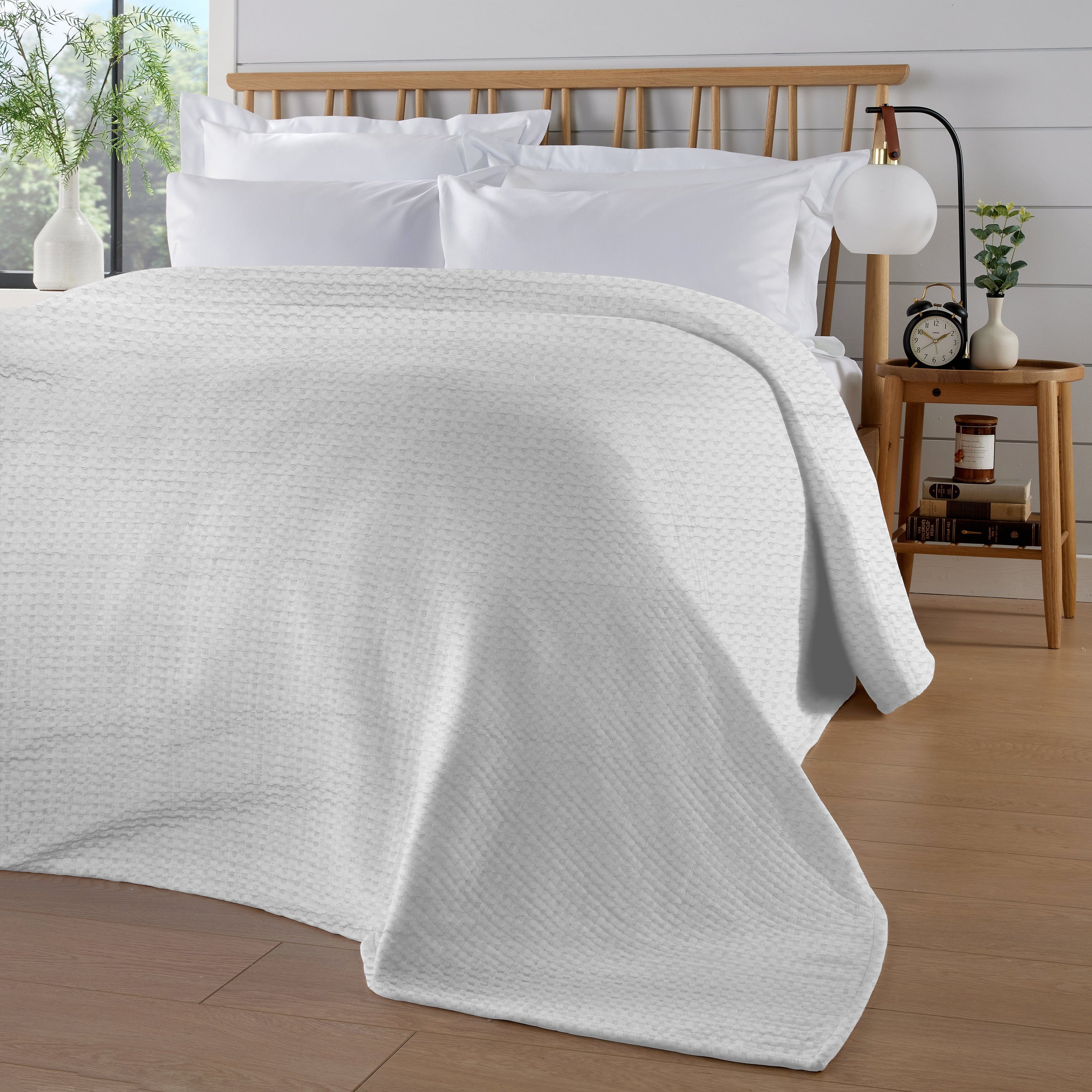 OLIVIA ROCCO Florian Checked Throw Blanket in white 100% cotton draped over a grey sofa in a bright living room