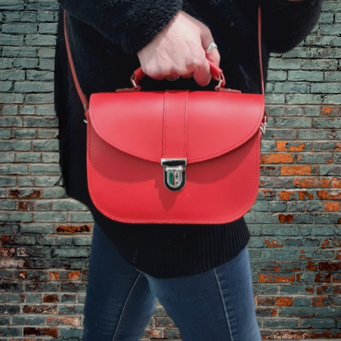 Woman wearing the Olympia Handmade Leather Bag in Pillar Box Red as a crossbody bag, showcasing the adjustable strap and structured silhouette