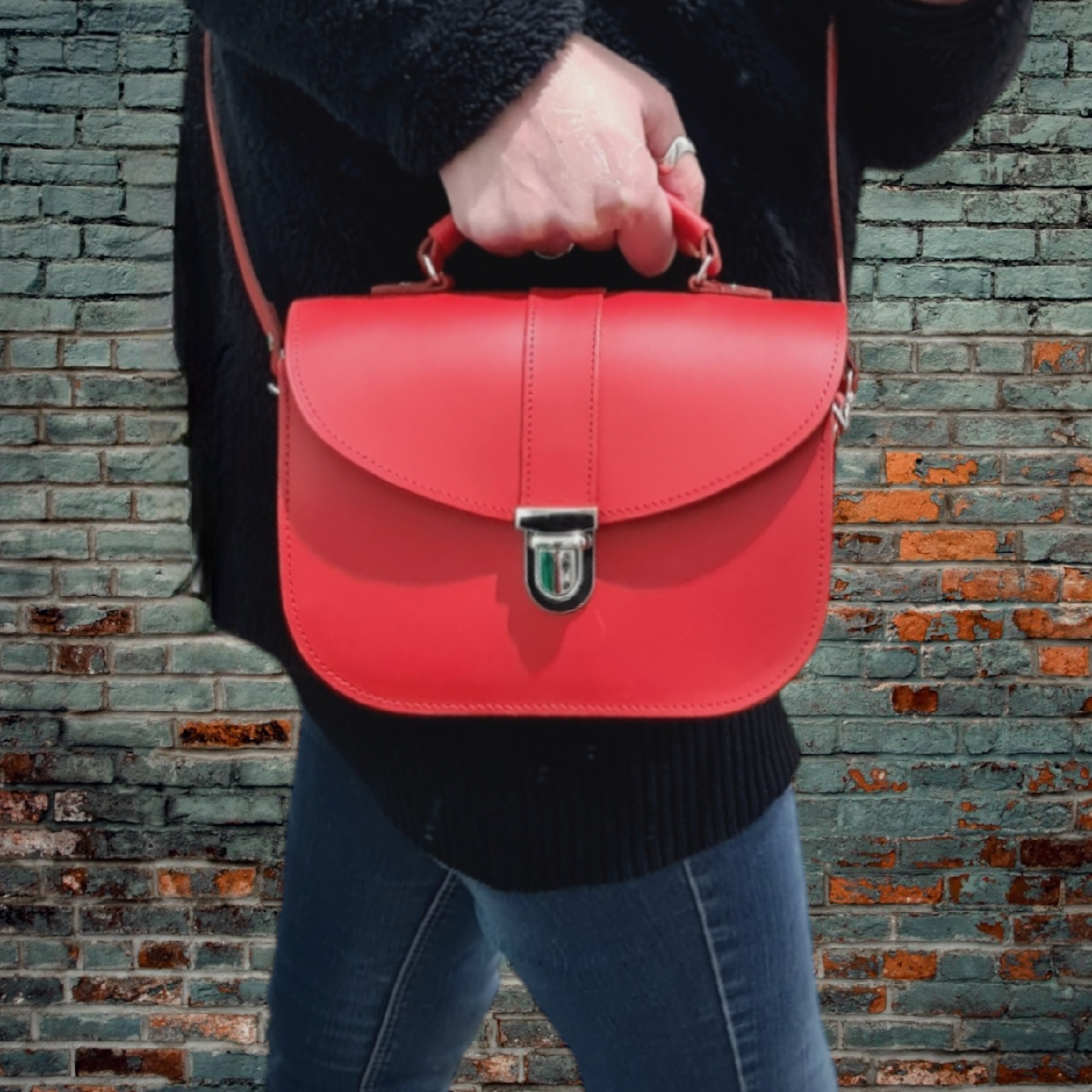 Woman wearing the Olympia Handmade Leather Bag in Pillar Box Red as a crossbody bag, showcasing the adjustable strap and structured silhouette