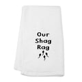 White towel with 'Our Shag Rag' text and graphic on a white background