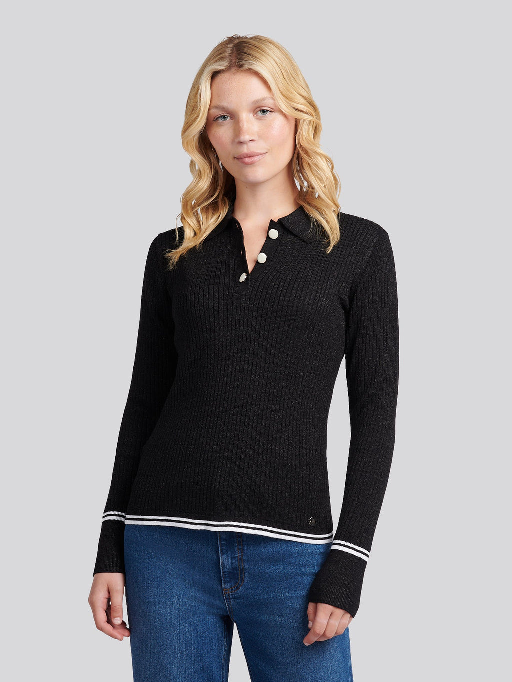 Woman wearing a black sweater with white trim on a gray background