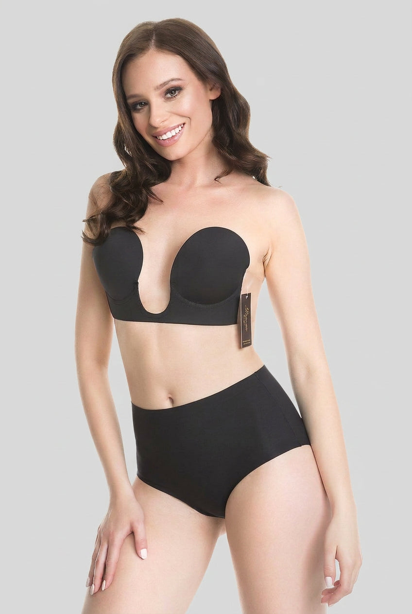 A woman modeling a black strapless bandeau bra and matching high-waisted briefs against a solid light gray studio background.